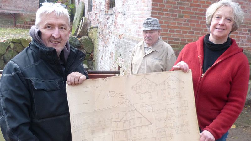 Mühlenbauer Olaf Rieck (von links), Müllermeister Franz Rosenkranz und die Mühlenvereins-Vorsitzende Emily Weede zeigen den detailreichen Bau- und Konstruktionsplan der Wassermühle Karoxbostel. | Foto: Verein Wassermühle Karoxbostel