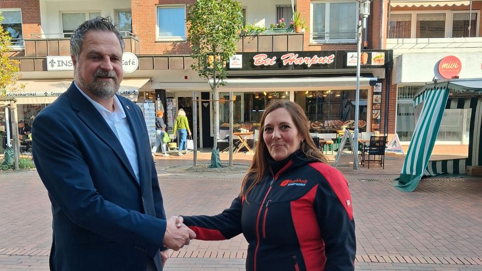 Michaela Voller (Stadtwerke Buchholz), Stadtbaurat Manuel Reichel und auf einem Foto Yasar Yildirim, der die Wasserpatenschaft übernommen hat. Foto: Stadt Buchholz