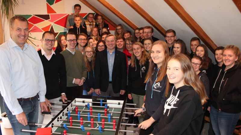 Das erste Spiel am Tischkicker in Elstorf ging klar mit 6:1 an die Evangelische Jugend. Andreas Sommer (links, Vorstandsvorsitzender der Sparkasse Harburg-Buxtehude), Stefan Weber (Beratungscenter-Leiter der Sparkasse Harburg-Buxtehude in Elstorf), Rechtsanwalt und Notar Dr. Martin C. Lockert, Nachbar Marko Seepolt, Pastorin Ruth-Stalmann-Wendt und (am Kicker) Johanna Köster und Elisa Ehlers. Im Hintergrund Mädchen und Jungen der Evangelischen Jugend Neu Wulmstorf/Elstorf. | Foto: ein